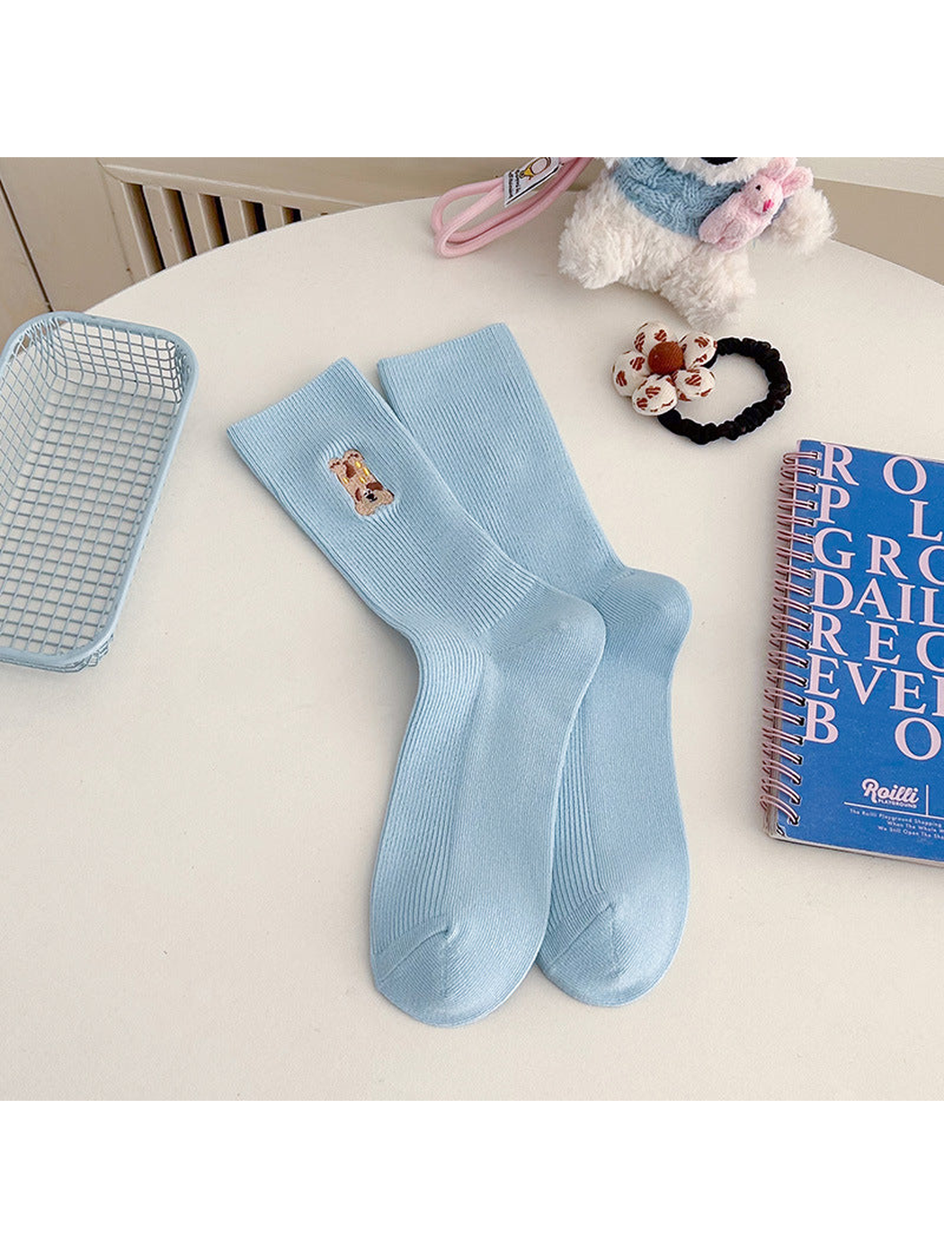 Light blue ribbed crew socks with an embroidered brown animal motif