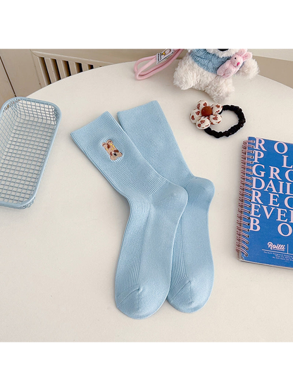 Light blue ribbed crew socks with an embroidered brown animal motif