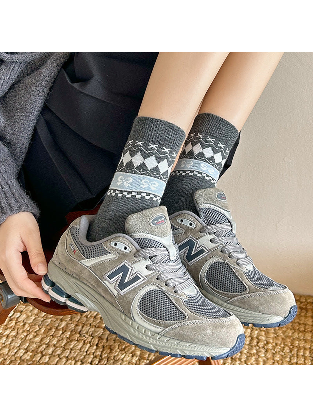 Dark gray patterned crew socks worn with gray sneakers