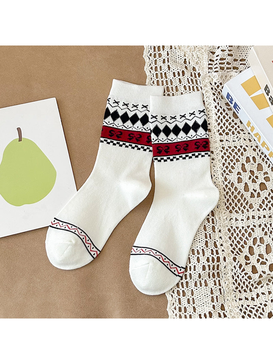 White crew socks with black diamonds and a red bow-patterned band