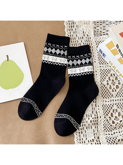 Black crew socks with white and gray patterned cuffs