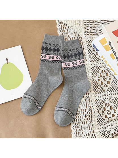 Heather gray crew socks with dark diamonds and a pink bow-patterned band