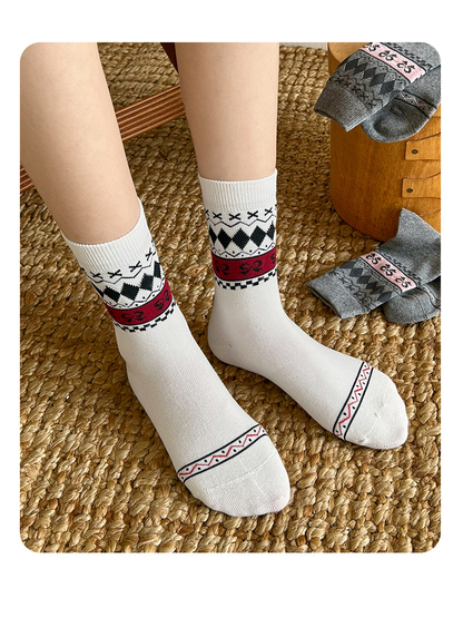 White patterned crew socks worn while standing on a woven rug