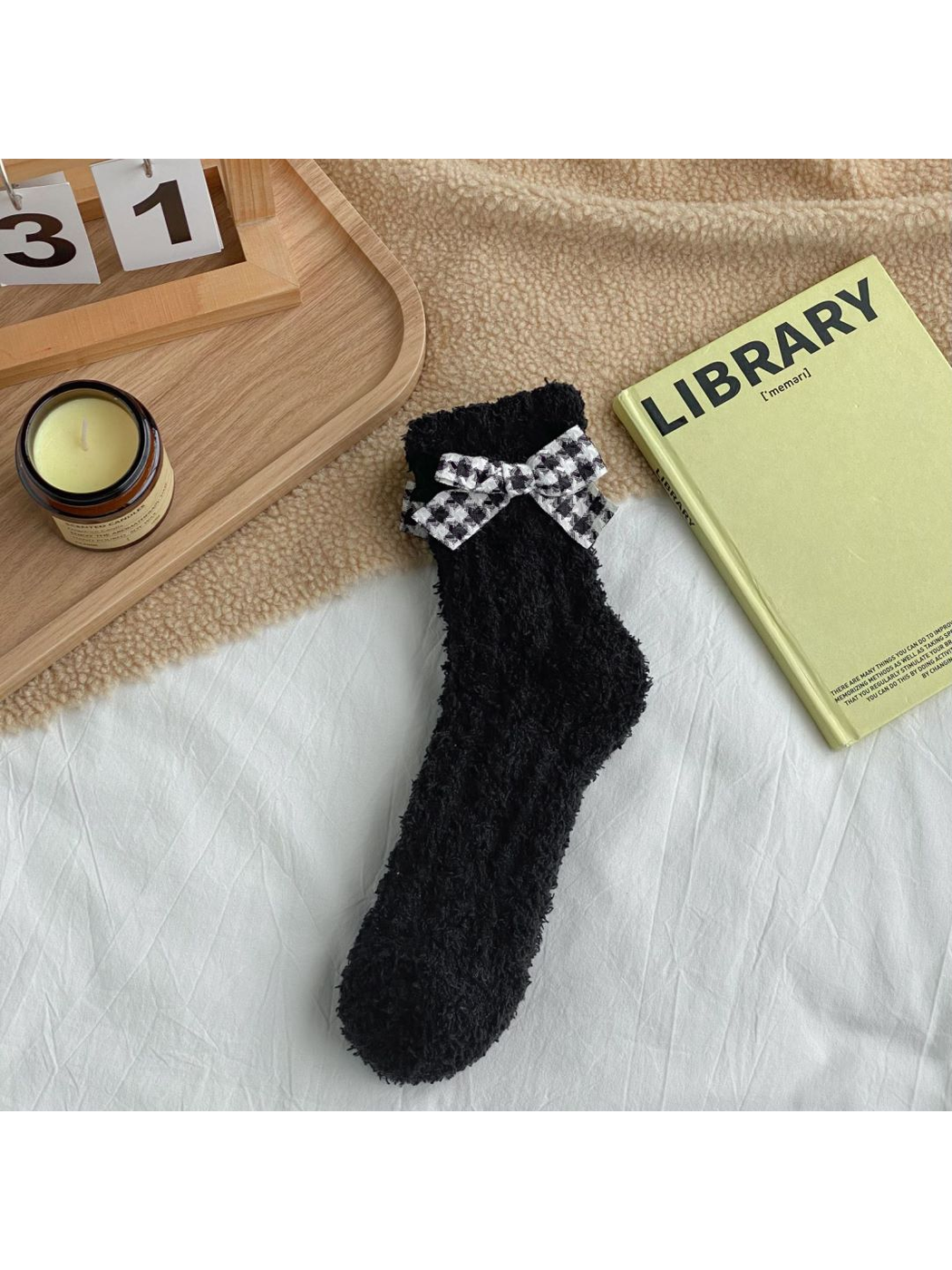 Black fuzzy socks with a black-and-white check bow