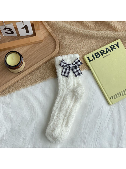 White fuzzy socks with a black-and-white check bow