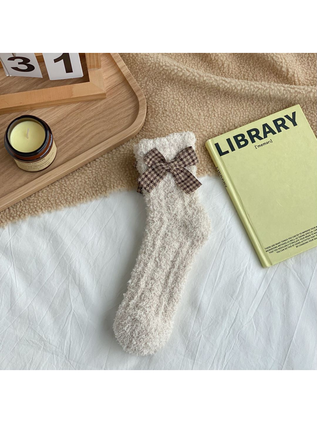 Beige fuzzy socks with a brown check bow