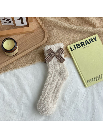 Beige fuzzy socks with a brown check bow