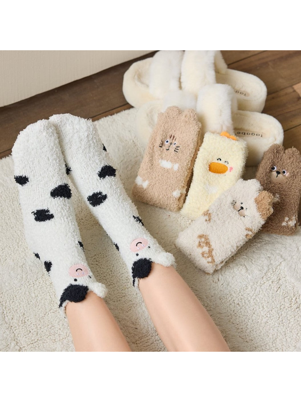 Fuzzy animal motif crew socks displayed together with a cow pair worn
