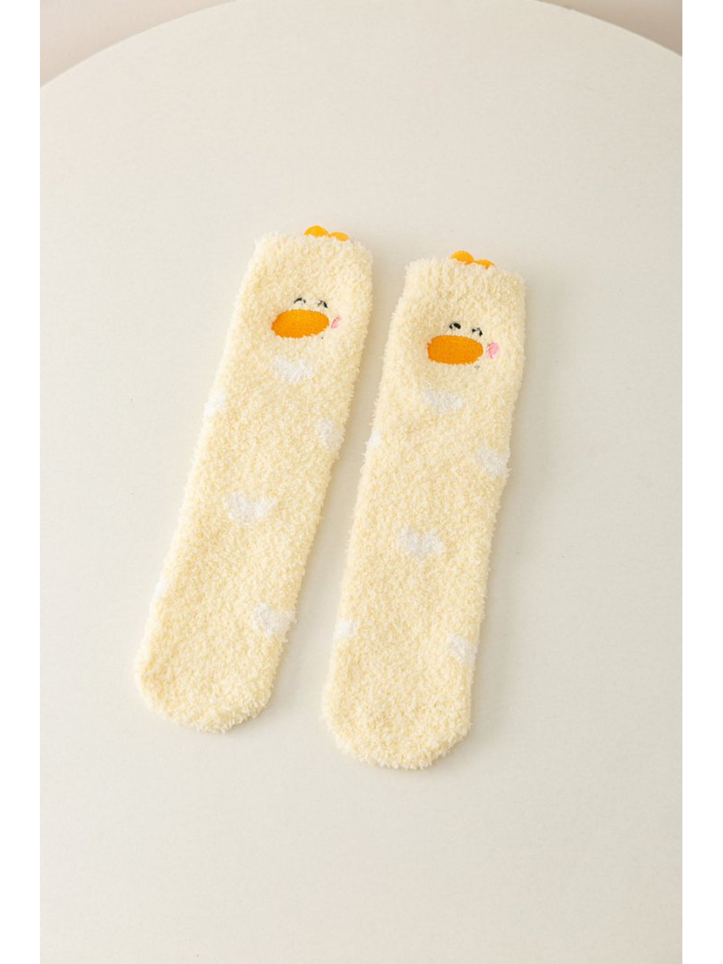 Yellow fuzzy crew socks with duck faces and white markings