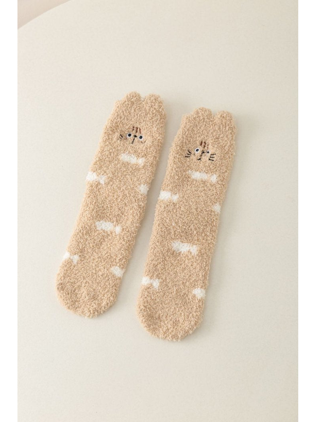 Beige fuzzy crew socks with cat faces and white markings