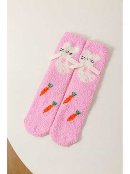 Pink fuzzy crew socks with a white cat and carrot motifs