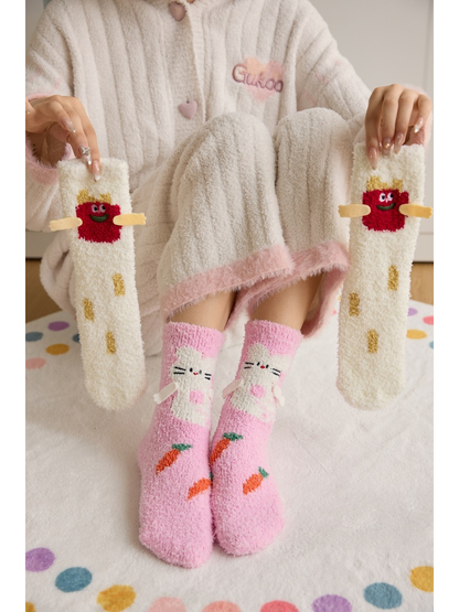 Pink cat crew socks worn while a pair of white character socks is held alongside
