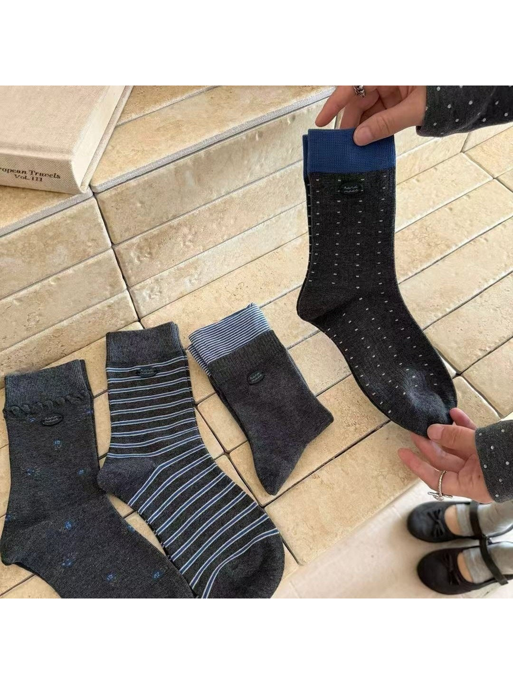 Four dark gray crew sock patterns displayed together, including floral, striped and dotted styles