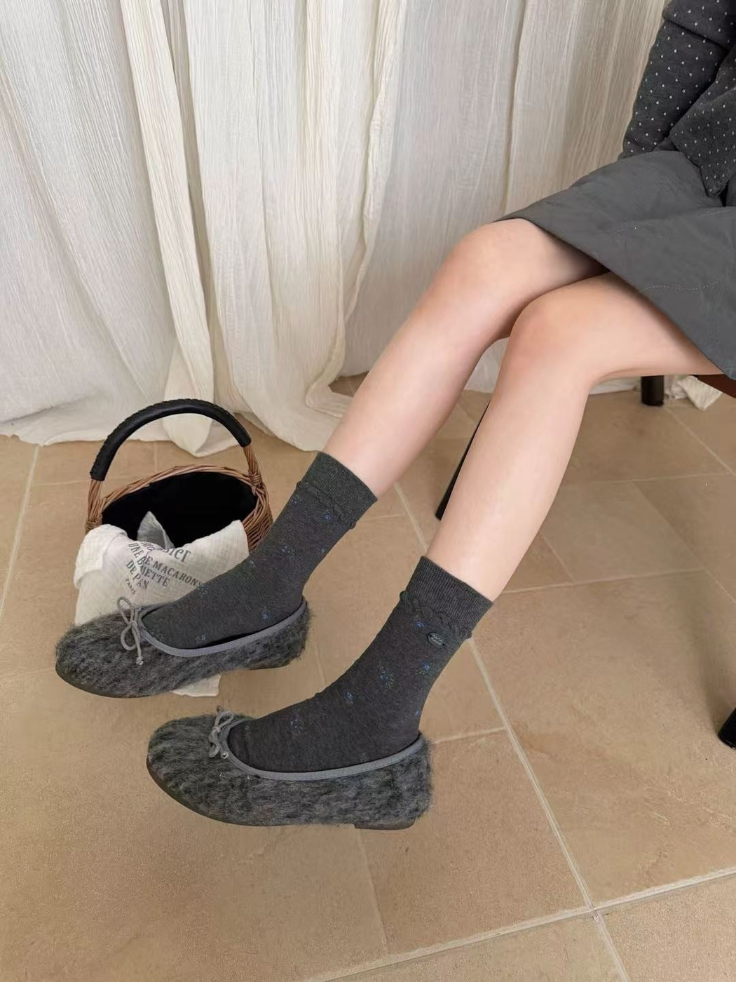 Dark gray crew socks with scattered blue floral motifs, worn view