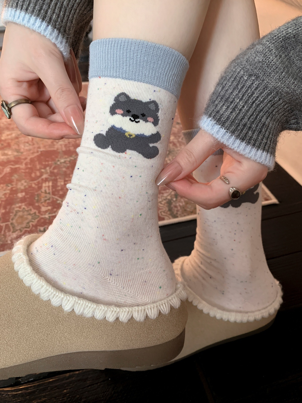 Ivory speckled bear motif crew socks worn with beige slippers