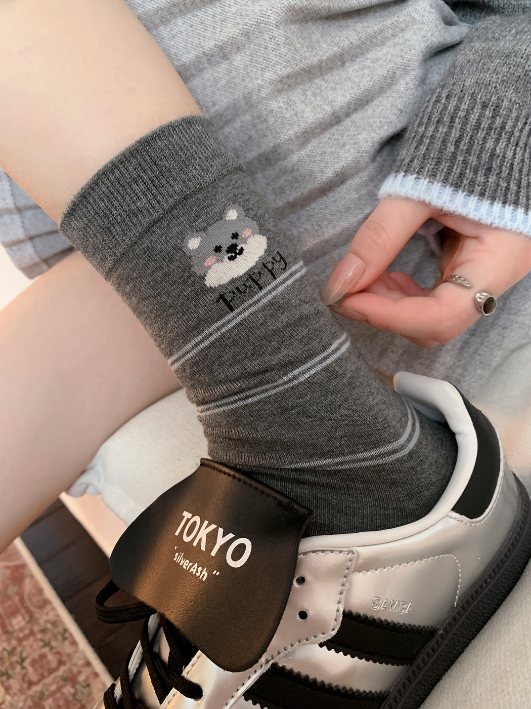 Dark gray striped dog motif crew sock worn with a silver sneaker