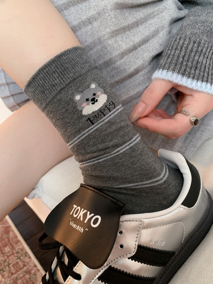 Dark gray striped dog motif crew sock worn with a silver sneaker