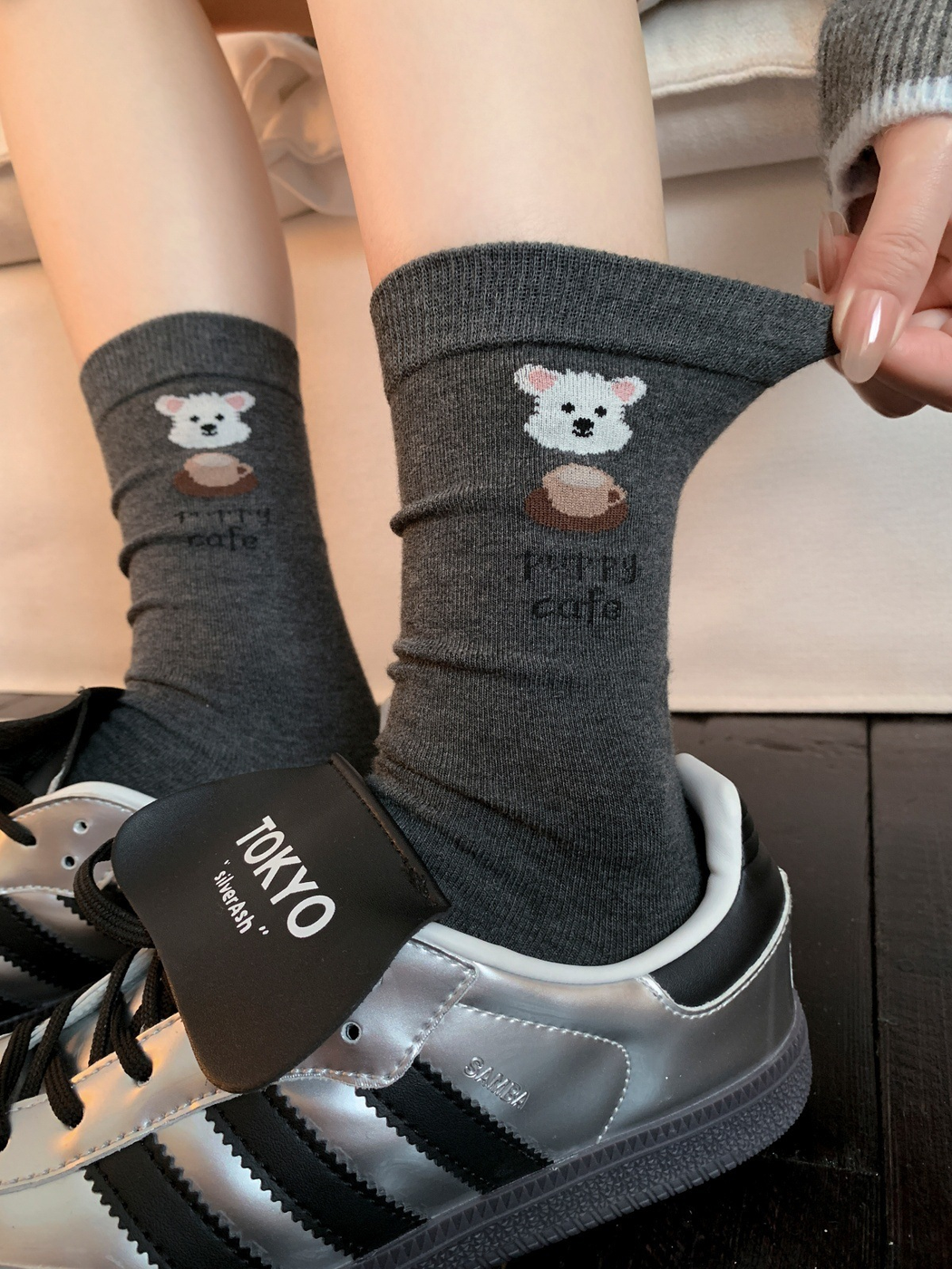 Dark gray coffee dog motif crew socks worn with silver sneakers