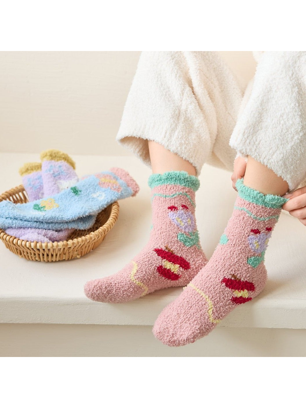 Dusty pink fuzzy floral socks worn while seated