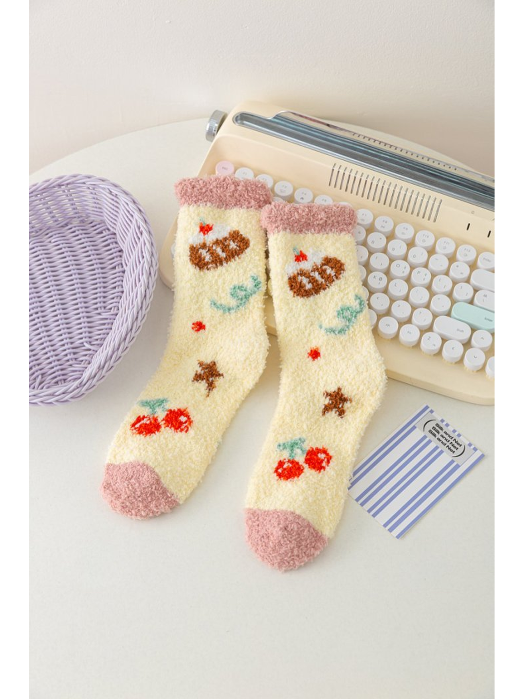 Pale yellow fuzzy socks with cherry motifs and dusty pink trim