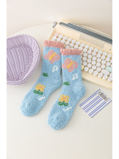 Light blue fuzzy socks with butterfly and flower motifs