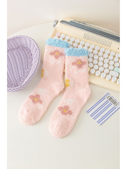 Light pink fuzzy socks with flower motifs and blue cuffs