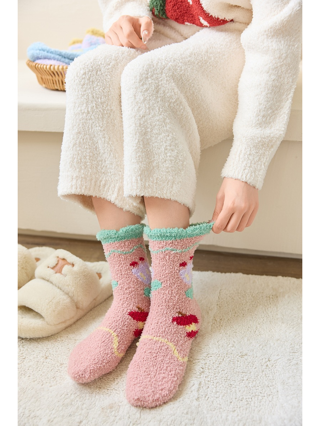 Dusty pink fuzzy tulip-pattern socks worn with the cuffs being adjusted
