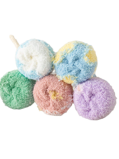 Close-up of five rolled socks showing their fuzzy texture and contrasting colors