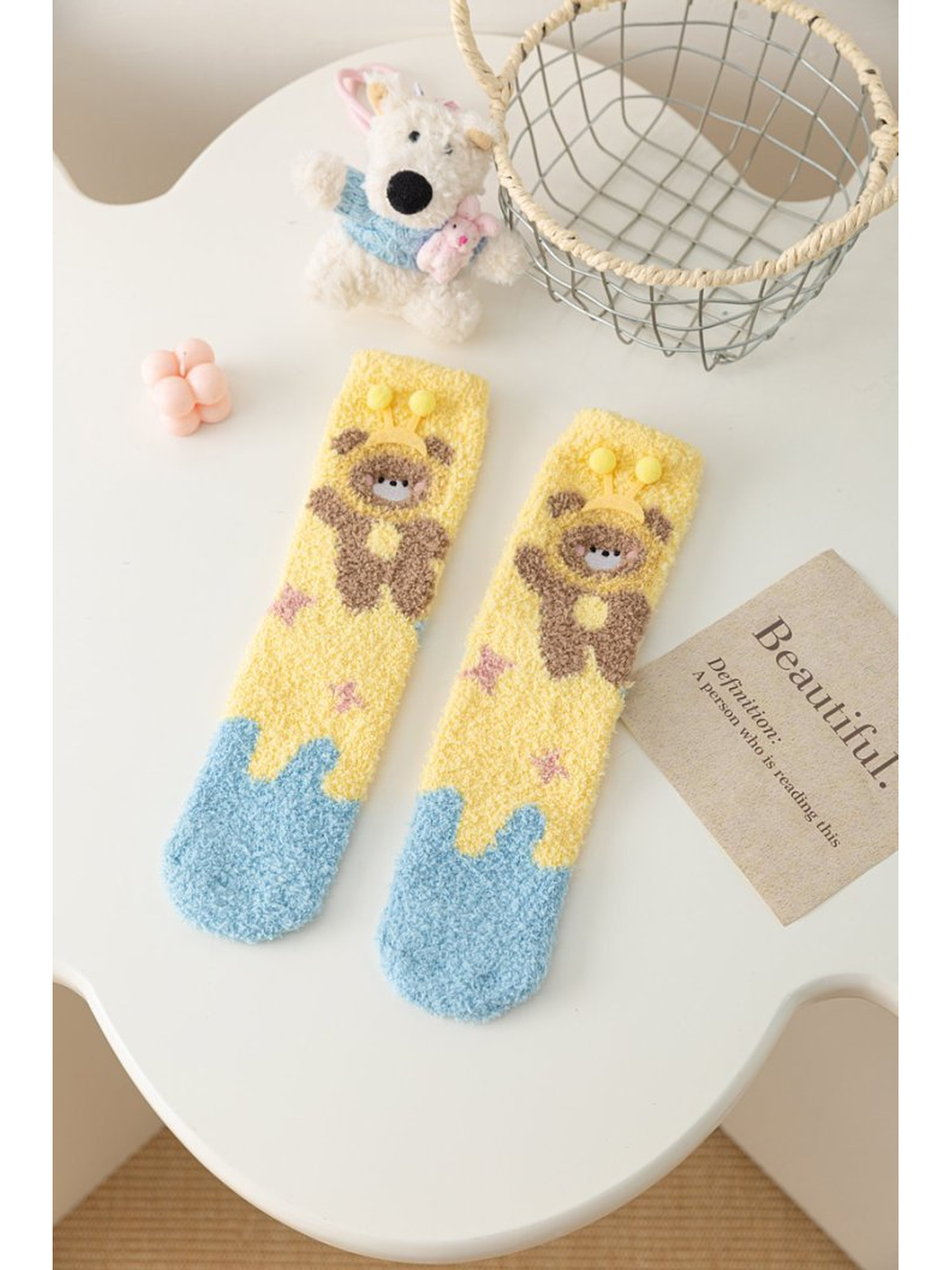 Yellow fuzzy socks with brown character motif and light blue toes
