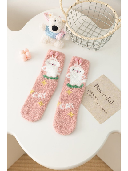 Dusty pink fuzzy socks with white bunny motif and star accents