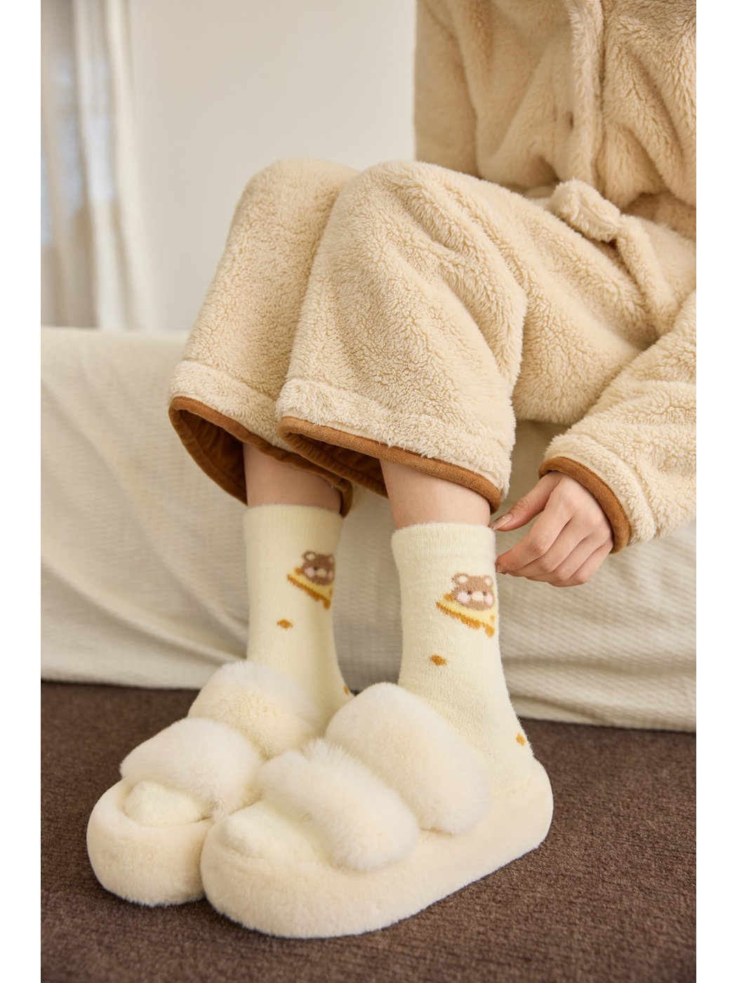 Ivory bear-and-dot crew socks worn with cream slippers