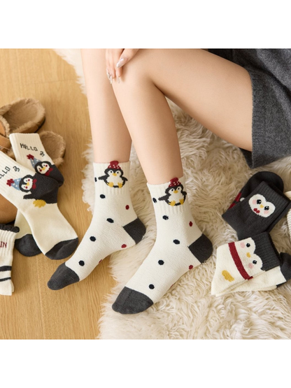 Penguin-pattern crew socks styled with slippers alongside several coordinating designs