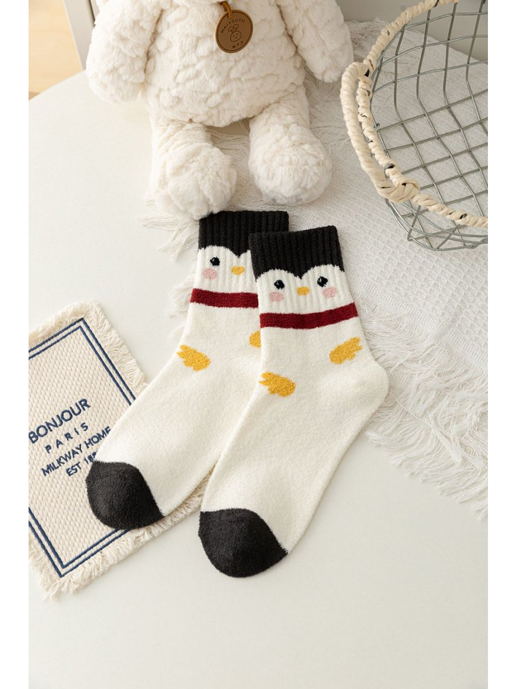 Ivory crew socks with penguin faces, dark cuffs and red ankle bands