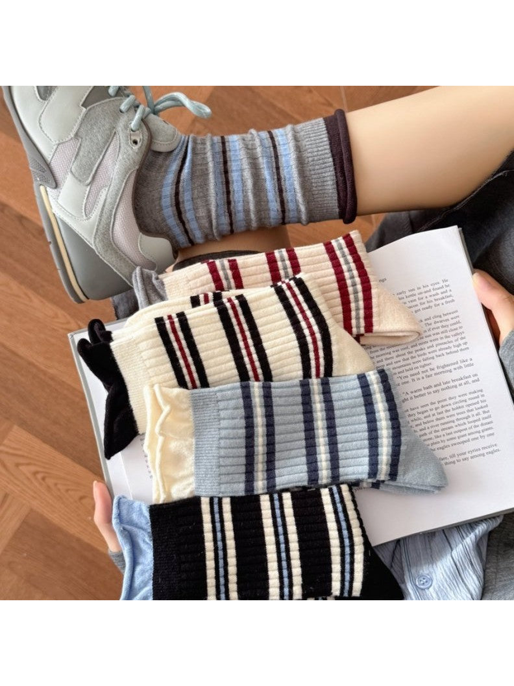 Striped crew socks in several colors styled with a sneaker and open book