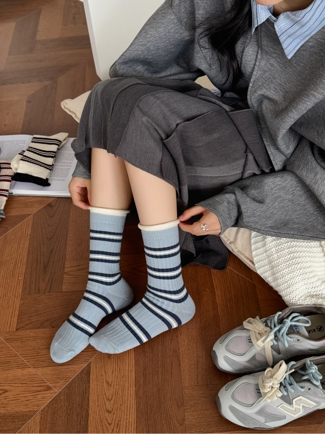 Light blue striped crew socks worn in a seated indoor setting