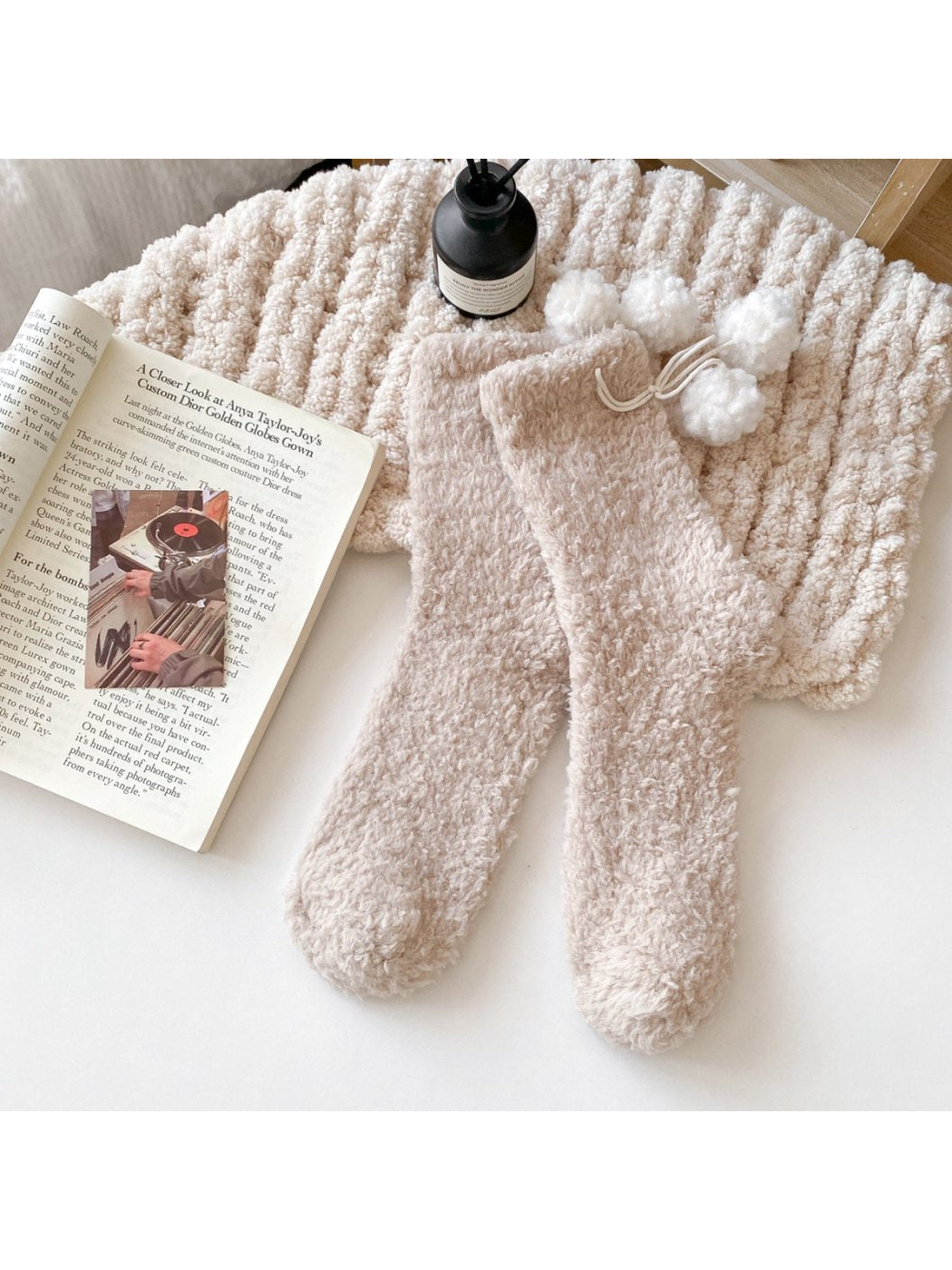 Beige fuzzy socks with white pom-pom ties