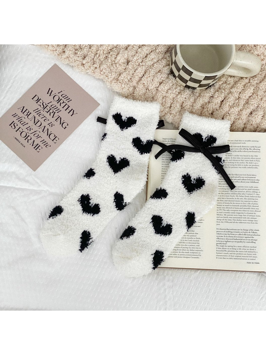 White fuzzy socks with large black hearts and a black ribbon bow