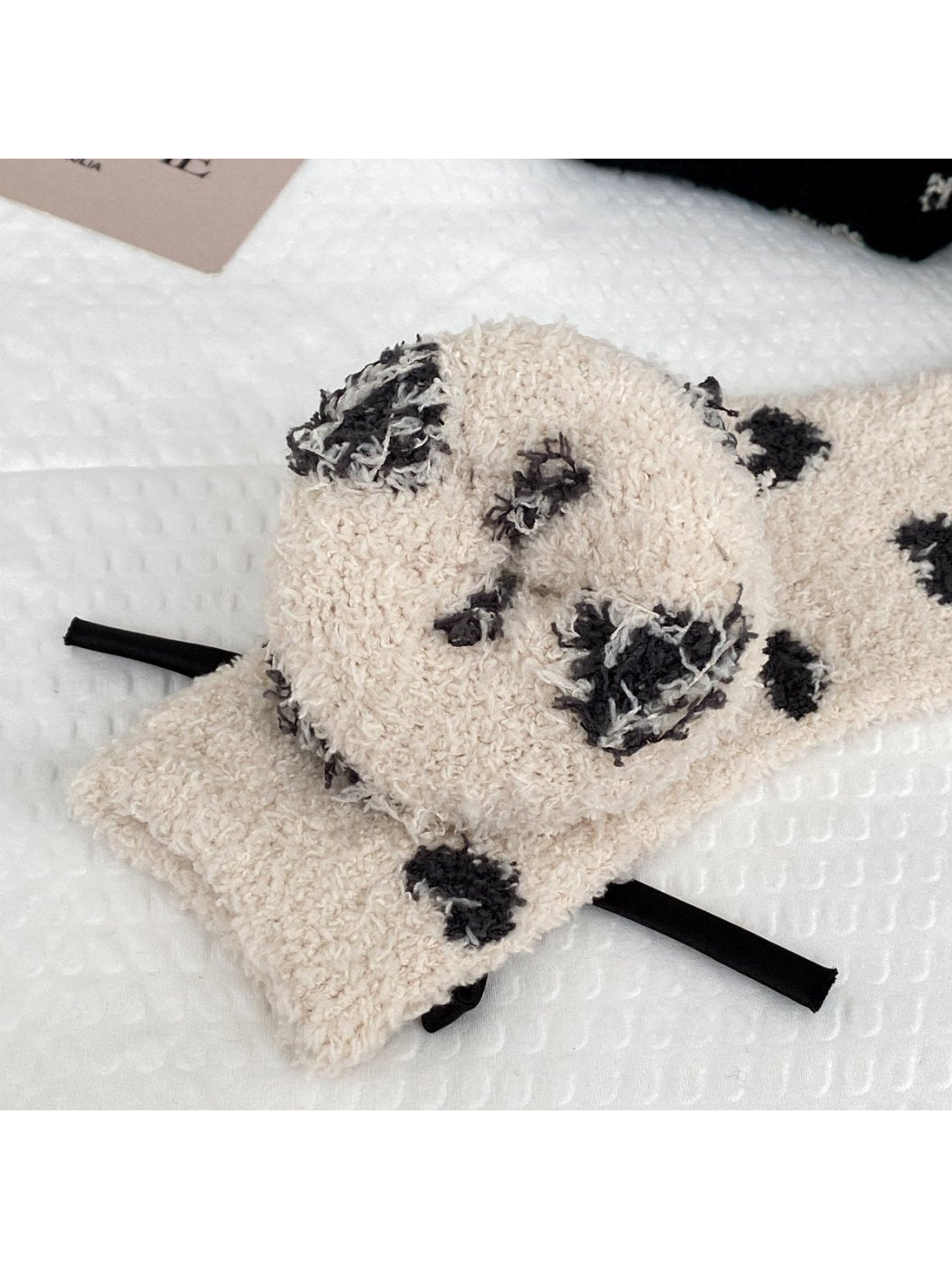 Close-up of beige fuzzy socks with dark heart motifs