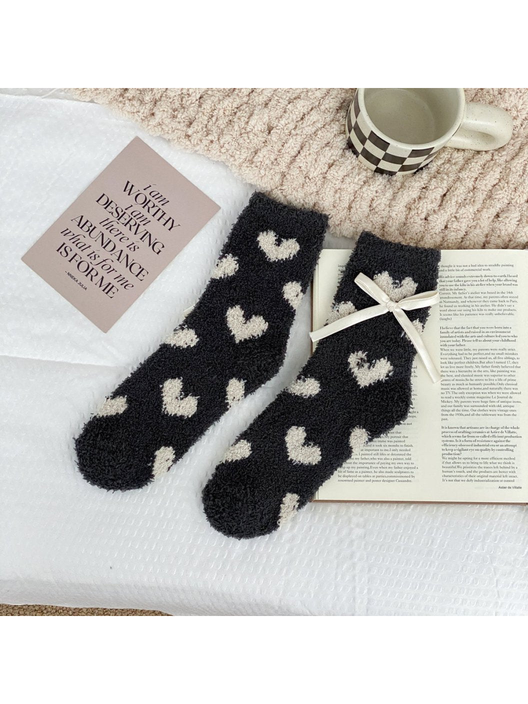 Dark gray fuzzy socks with large cream hearts and a cream ribbon bow