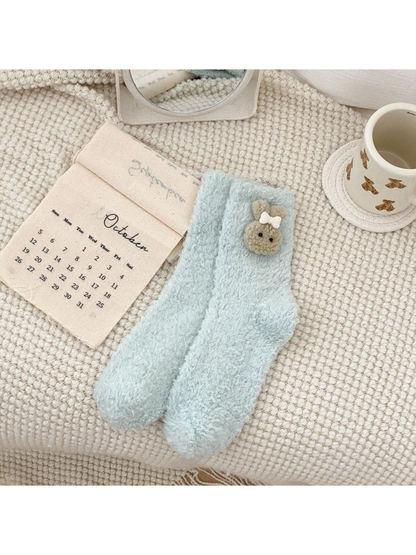 Pale blue-green fuzzy crew socks with an animal-face applique