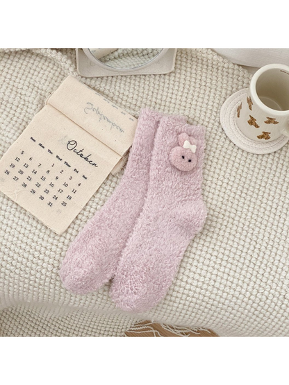 Light pink fuzzy crew socks with a pink animal-face applique