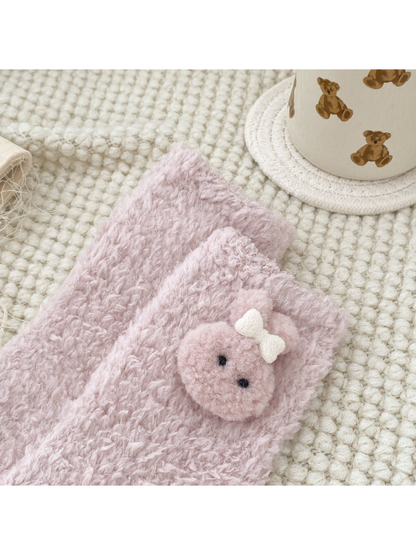 Close-up of a pink animal-face applique near the sock cuff