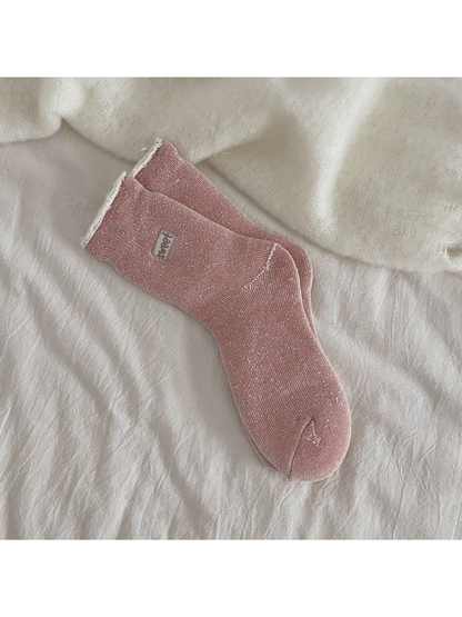 Dusty pink ribbed crew socks with a rolled cuff and small label patch