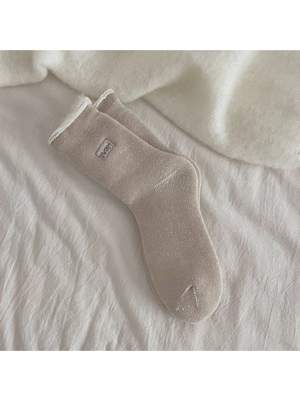 Light coffee ribbed crew socks with a rolled cuff and small label patch