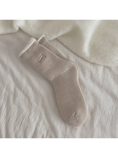 Light coffee ribbed crew socks with a rolled cuff and small label patch
