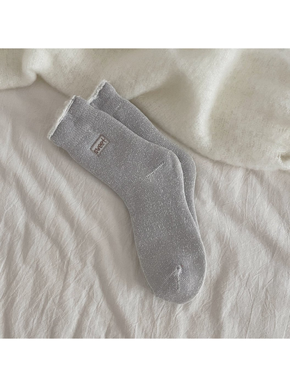 Gray ribbed crew socks with a rolled cuff and small label patch