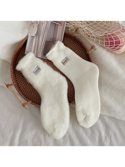 Close-up comparing the fuzzy inner surface and ribbed outer surface of ivory socks