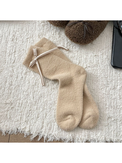 Beige fuzzy crew socks with a ribbon bow