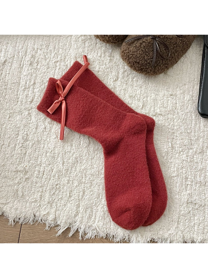 Red fuzzy crew socks with a matching ribbon bow