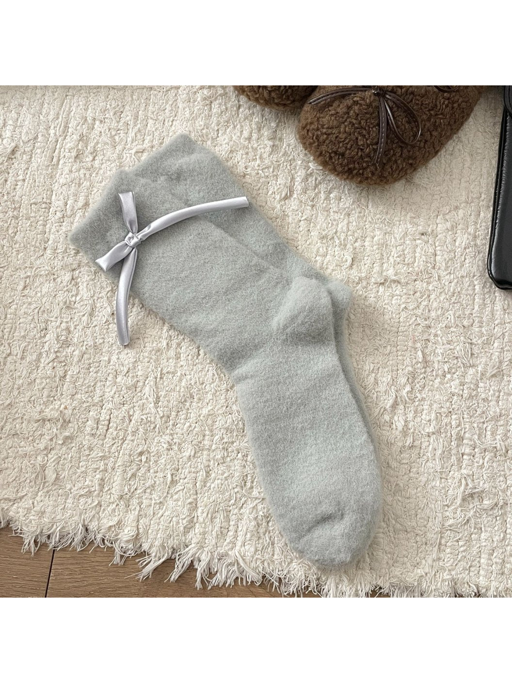 Light gray fuzzy crew socks with a silver ribbon bow